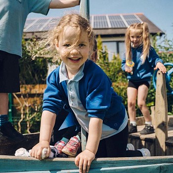 merch ifanc yn gwenu wrth fod y tu allan