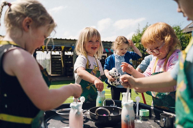 group of happy children playing in Cylch Meithrin Felinheli's outdoor area