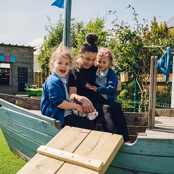 athro gyda 2 fyfyriwr ar gwch chwarae