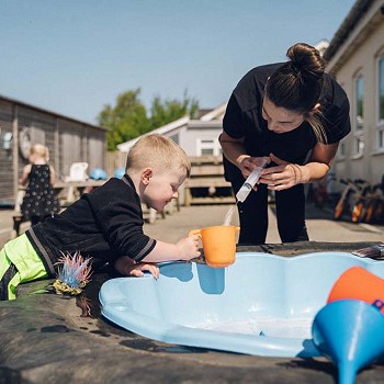 myfyriwr a phlentyn yn chwarae gyda dŵr